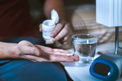 Un hombre toma un medicamento contra el insomnio.