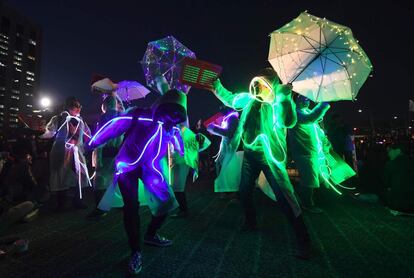 Varios manifestantes surcoreanos visten trajes luminosos en una manifestación a la luz de las velas exigiendo el arresto de la presidenta Park-Geun-Hye en Seúl, Corea del Sur.