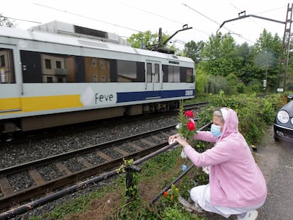 Una mujer coloca flores en el lugar del atropello ferroviario de dos mujeres en Torrelavega.