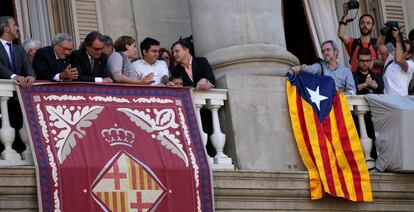 Moment en què comença a ser desplegada l'estelada a la balconada de l'Ajuntament de Barcelona mentre les personalitats surten a saludar els centenars de persones que es troben a la plaça de Sant Jaume.