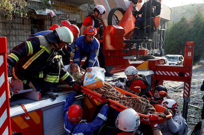 Persona de emergencia traslada este martes a uno de los heridos de un bombardeo ruso sobre un edificio en Kiev, este martes.