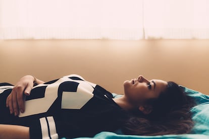 Una mujer joven tumbada en la cama.