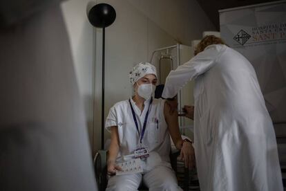 Una enfermera vacuna a un profesional sanitario con la vacuna de Pfizer-BioNtech contra el COVID-19 en el Hospital de la Santa Creu i Sant Pau de Barcelona.