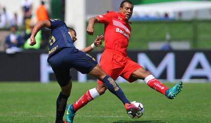 Paulo da Silva del Toluca disputa un balón con Eduardo Herrera de Pumas.