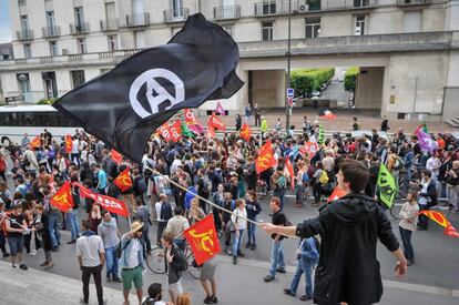 Un joven con una bandera anarquista durante una protesta contra las reformas de trabajo en Tours.