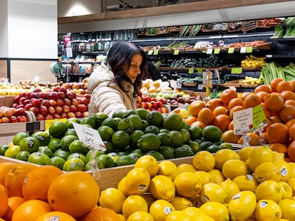 Una mujer elige frutas en un supermercado en Nueva York, en enero de 2024.