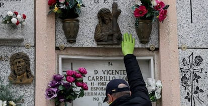 Un hombre visita el nicho de su madre en un cementerio de Madrid.