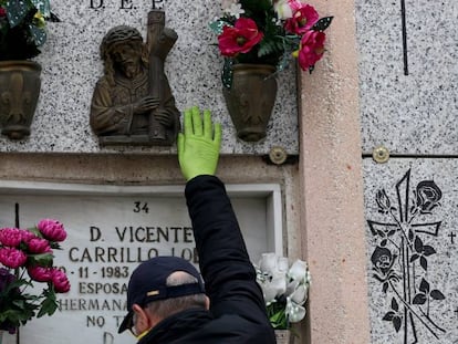 Un hombre visita el nicho de su madre en un cementerio de Madrid.