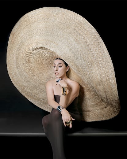 Pulseras Bone Cuff en oro y plata, creación que en 2019 cumplió 50 años y probablemente sea el diseño más icónico de Elsa Peretti para Tiffany & Co. Sombrero de paja natural de Eliurpi y vestido tubo de Wolford.