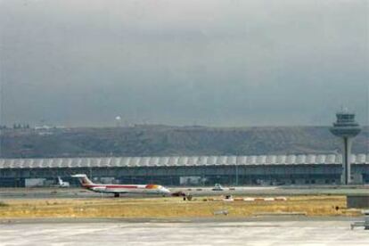 Un avión junto a la nueva terminal del aeropuerto madrileño de Barajas. A la derecha, la torre de control aéreo.