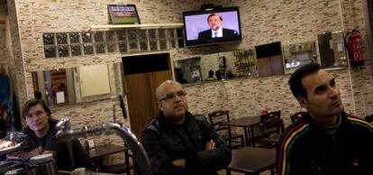 Varios clientes siguen el debate en un bar de Barcelona.