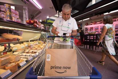 Un trabajador de Amazon en el Mercado de la Paz hace la cesta de la compra para un cliente online.