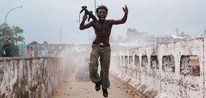 Joseph Duo, when he was a child soldier, leaps after having unloaded a grenade launcher during the civil was in Liberia.