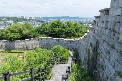 Construida como obra defensiva a lo largo del año 1396 en dos tandas, esta muralla con muros de unos 7-8 metros de alto recorre 10 kilómetros (tenía unos 18) alrededor de Seúl. Las montañas Bugaksan, Naksan, Namsan e Inwangsan están unidas por esta larga sucesión de escalones. Siguiendo el muro, se construyeron ocho puertas. Se conservan seis, y las de Sukjeongmun, Heunginjimun, Sungnyemun y Dongeuimun son las más importantes. Al ser considerada una zona militar, hay que vigilar porque hay tramos del recorrido por la muralla en los que no se permite tomar fotografías. Más información: <a href="http://english.visitseoul.net/index" target="_blank">visitseoul.net</a>