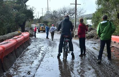 Residentes locales observan la carretera cortada en Carpinteria, California, depsués de que cayeran rocas por la ladera tras las intensas lluvias, el 9 de enero de 2018.