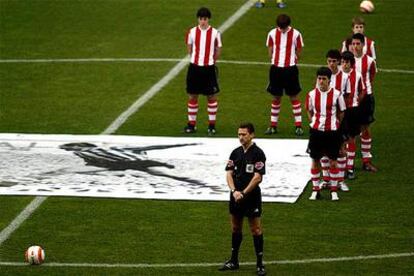 El árbitro Daudén Ibáñez y juveniles del Athletic en el minuto de silencio en recuerdo de Zarra.