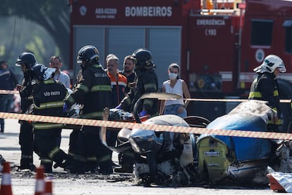 Varios bomberos retiran los cuerpos de las victimas del accidente areo este viernes, en S?o Paulo (Brasil).