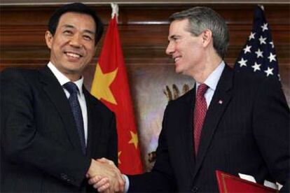 El ministro de Comercio chino, Bo Xiliai, y el de EE UU, Rob Portman, tras la firma del acuerdo en Londres.