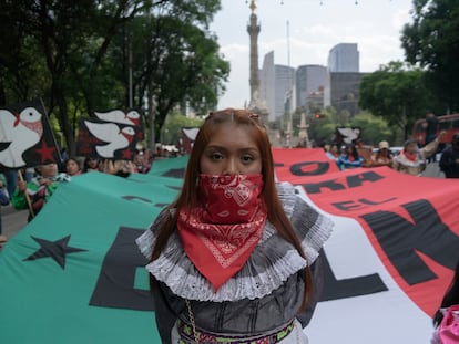 Una joven marcha frente a una bandera que lee "Alto a la guerra contra el EZLN", el 8 de junio en Ciudad de México.