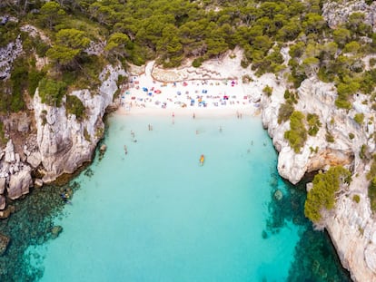 Es todo eso que un mitómano de las playas podría desear. Una piscina centelleante y adánica, a la que se llega por un sendero, si bien algunos optan por hacerlo a nado desde su hermana mayor, la Macarella, está sí equipada con chiringuito. La Macarelleta es una zona privilegiada tanto por las encinas y los pinos que se inclinan sobre el mar como por su arena blanca depurada y su carácter recoleto. Sus aguas de coloraciones turquesas, vistas a distancia, generan un efecto óptico de embarcaciones que, ingrávidas, parecen levitar. A Macarella solo se puede acceder en autobús desde Ciudadela <a href="http://www.bus2macarella.com/" target="_blank">(bus2macarella.com)</a> o a pie, en una caminata de 30 minutos desde cala Galdana.