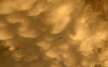 Un avión vuela hacia el aeropuerto internacional de O'Hare bajo un mar de nubes, en Chicago.