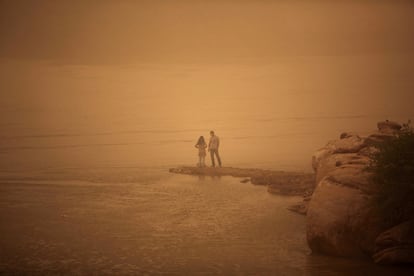 Una pareja permanece a orillas del río Arvandrud durante una tormenta de arena que ha afectado a la ciudad de Ahvaz, al suroeste del Irán. La tormenta, de una magnitud sin precedentes y originaria del vecino Irak, ha obligado a cerrar colegios y oficinas oficiales.