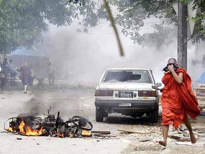 Un monje budista pasa junto a una motocicleta incendiada tras los incidentes ocurridos ayer en Yangon, en una foto divulgada por la Liga Nacional para la Democracia de Suu Kyi.