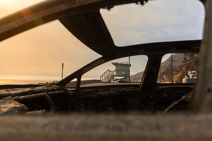 Una de las célebres casetas de la playa de Malibú, vista a través de las inexistentes ventanillas de un coche calcinado por el incendio de Los Ángeles. 