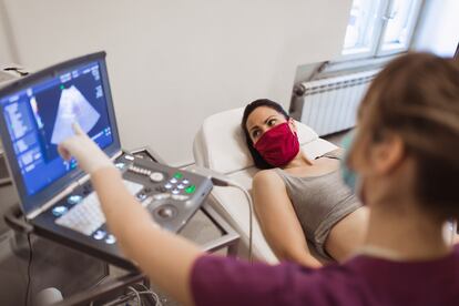 Una doctora realiza una ecografía de diagnóstico prenatal a una mujer embarazada. 