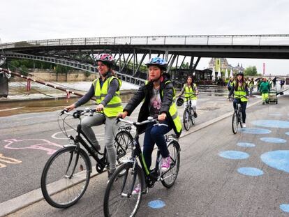 Unas j&oacute;venes pasean en bicicleta en una carretera junto al Sena.