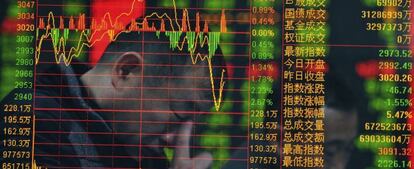 Fotografía con efecto de doble exposición que muestra a un inversor con los precios de las acciones en una agencia de corretaje en Fuyang, en la provincia central china de Anhui.