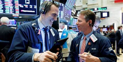 Dos corredores celebran el cierre en verde de Wall Street, en septiembre, en Nueva York (EE UU).