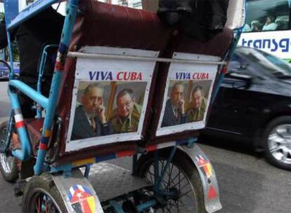 Un bicitaxista circula por La Habana con su vehículo decorado con fotografías de Fidel y Raúl Castro