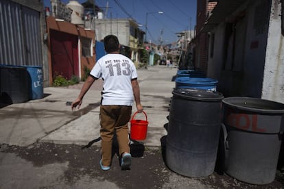 Un vecino de Iztapalapa transporta cubos de agua.