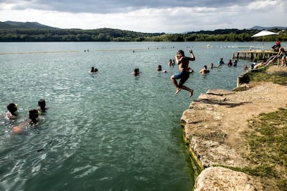 Un niño se lanza al agua del lago de Banyoles, en Girona.