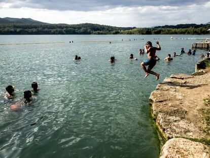 Un niño se lanza al agua del lago de Banyoles, en Girona.