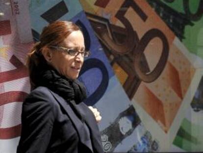 Una mujer pasa frente a un cartel con la imagen de billetes de diferentes cantidades de euro. EFE/Archivo