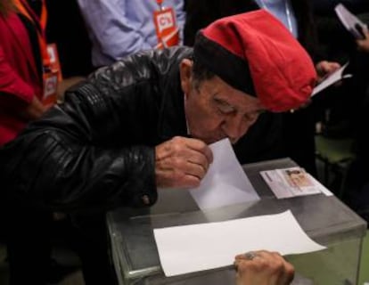 A man wearing a 'barretina', the traditional Catalan hat, kisses his ballot while voting in Catalonia's regional elections at a polling station in Barcelona