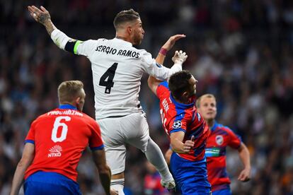 El defensa del Real Madrid, Sergio Ramos, salta para cabecear el balón ante el defensa del Pilsen, Radim Reznik, en una acción del encuentro disputado en el Santiago Bernabéu.