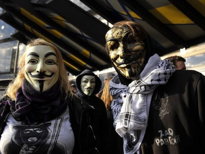 Tres persones amb la màscara de Guy Fawkes es manifesten en suport de tres 'hackers' davant d'un tribunal de Nancy (França) el 9 de novembre.