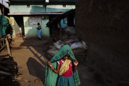 Una niña se cubre la cabeza con un velo frente a su casa en el poblado de Bodhali.