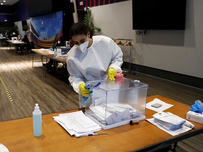 Una persona desinfecta una urna el Auditori Camp Non durante las últimas elecciones catalanas, celebras el pasado día 14 de febrero.