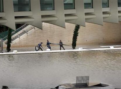 Imagen del Palau de les Arts del pasado 22 de octubre. Unos operarios achican agua de las piscinas exteriores por las lluvias.