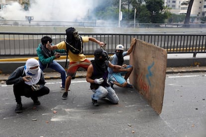 Manifestantes se preparan para tirar piedras durante la manifestación opositora en Caracas.