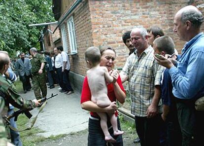 Una mujer con un niño en brazos llora en el momento de ser liberada del secuestro en una escuela de Beslán.