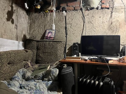 Una pequeña tele y un icono religioso, en el interior de un refugio en Limán, bajo constante fuego de artillería ruso.