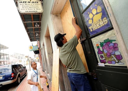 Vecinos de Nueva Orleans sellan una tienda ante la llegada del huracán Isaac.