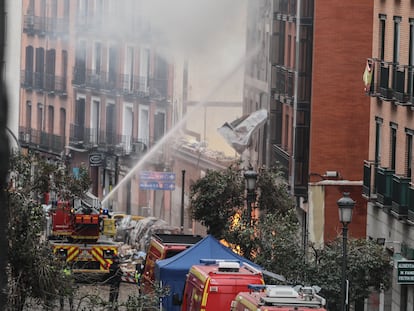 Los bomberos echan agua en el edificio situado en la calle Toledo 98, tras al explosión.