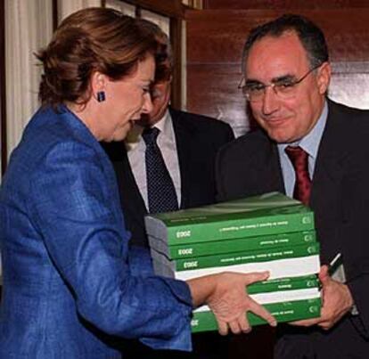 Magdalena Álvarez entrega al presidente del Parlamento, Javier Torres Vela, los tomos del presupuesto.