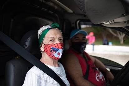 O casal Adélia Junqueira, 81, e Wallace Souza Diniz, 42, na fila do drive-thru do Pacaembu.